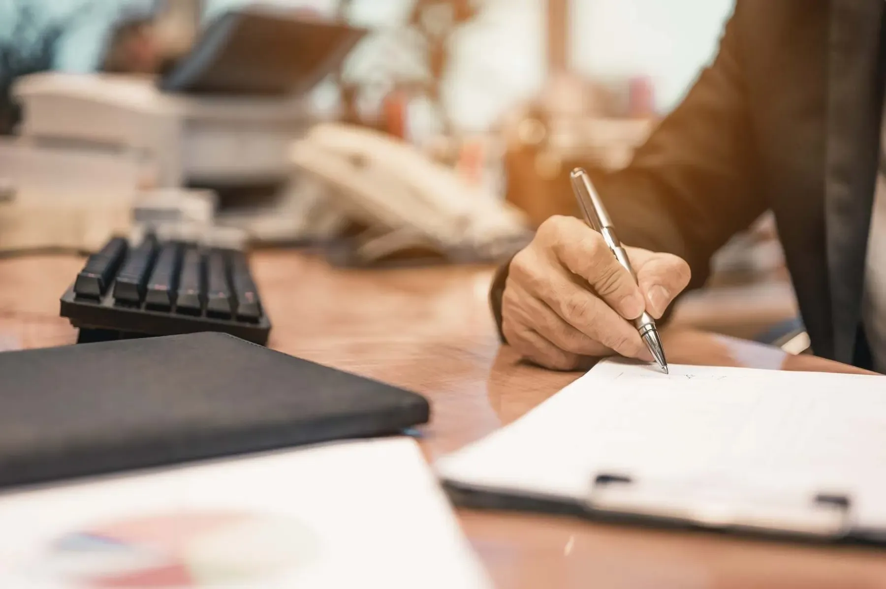 Accountant writing up client accounts at a desk McGrath Pattison Accountants Maghera