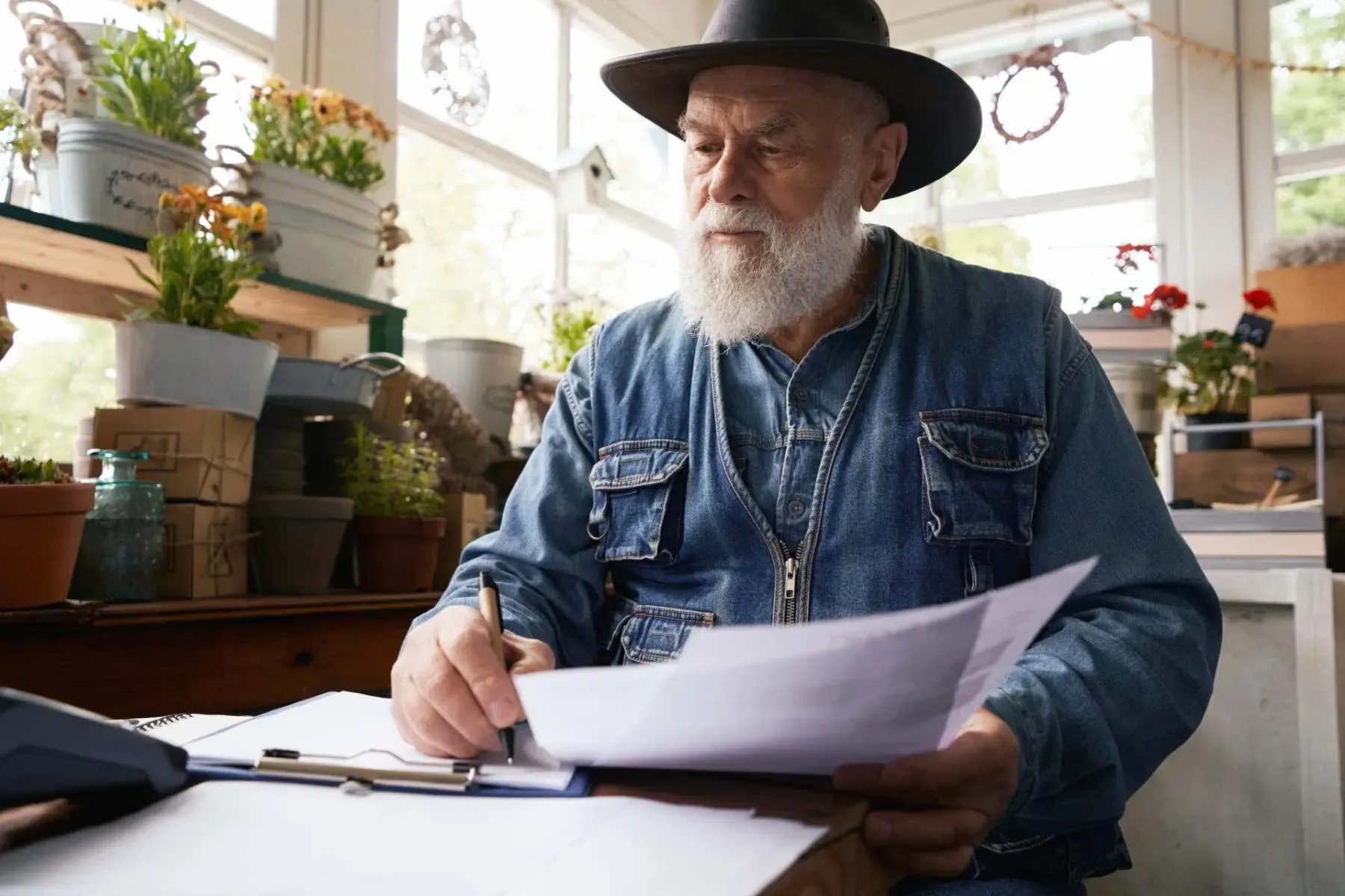Business owner checking accounts in his shop for pension auto enrolment McGrath Pattison Accountants